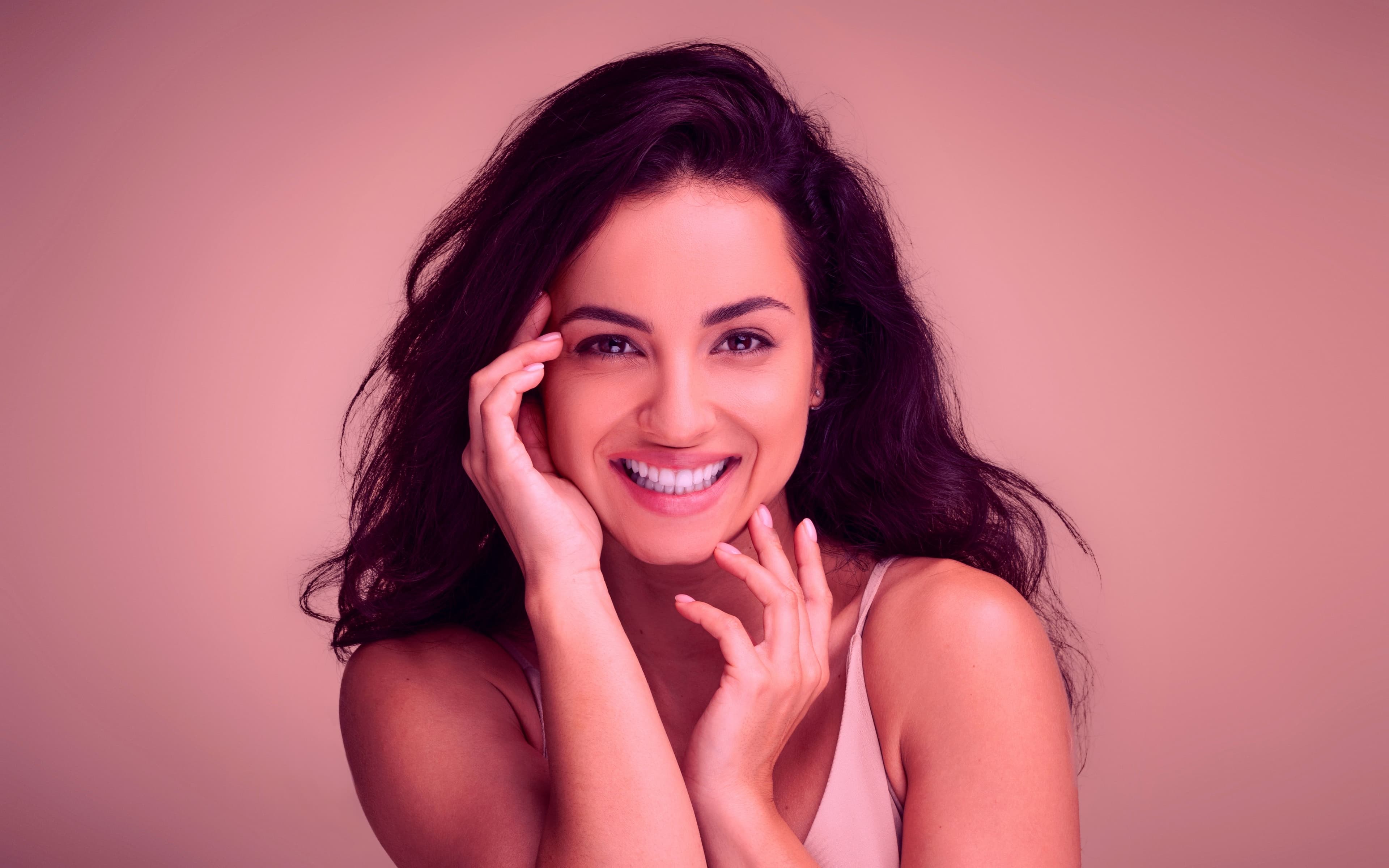 Mulher sorridente com a mão no rosto