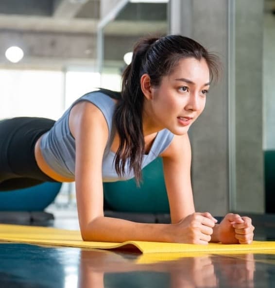 Mulher em prancha sobre o tapete de treino