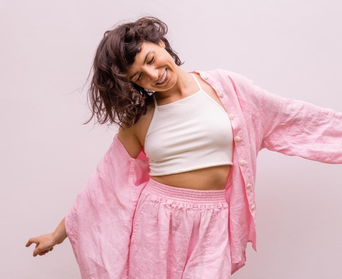 Mulher de pijama rosa sorrindo