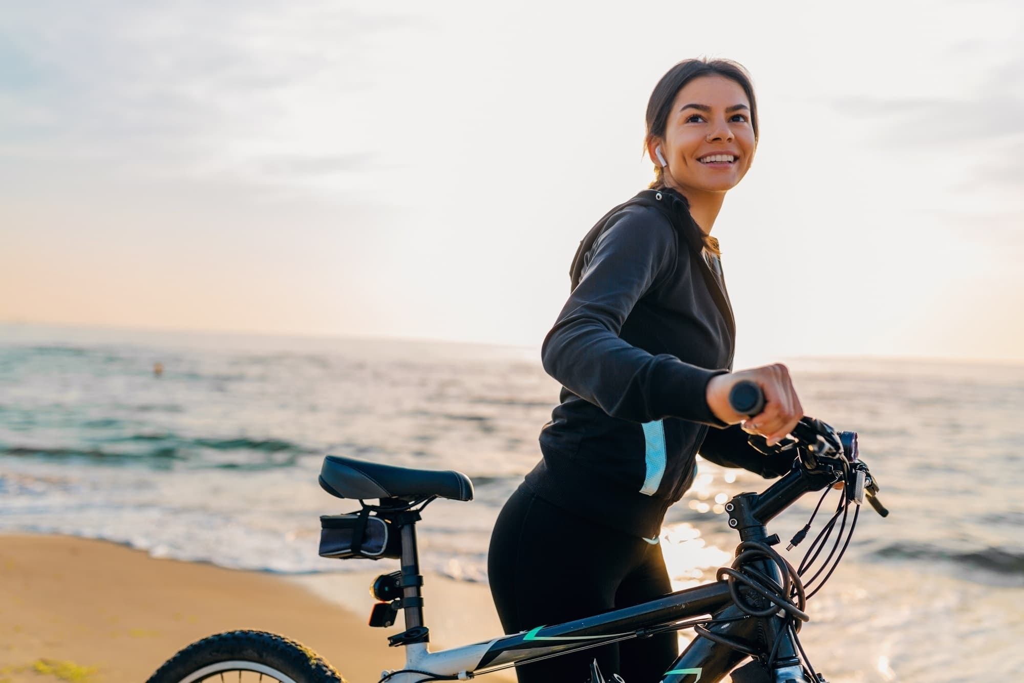 Mulher em bicicleta à beira-mar
