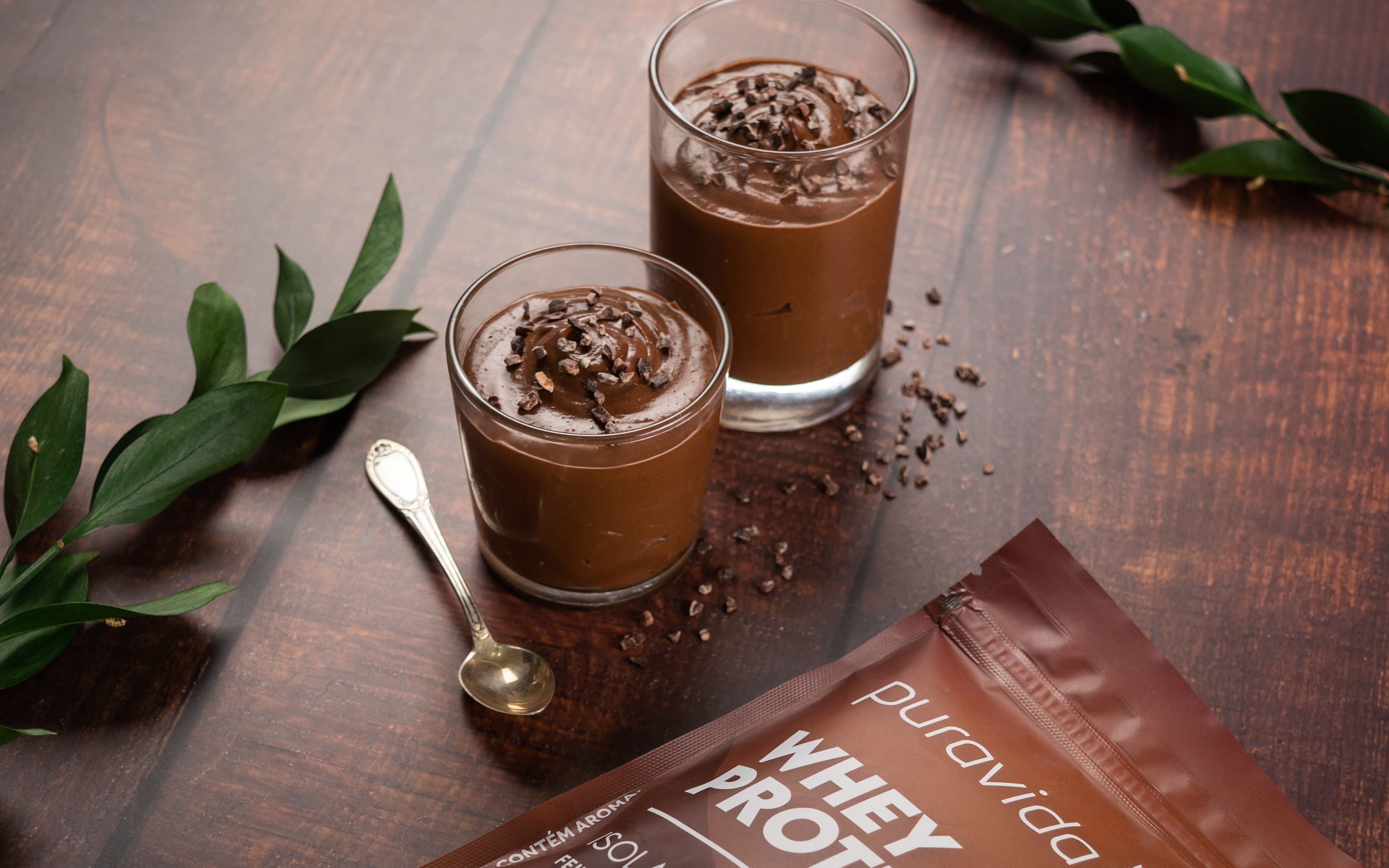 Copos com sobremesa de chocolate ao lado do Whey Protein Isolado Puravida