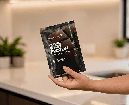 Mão segurando o pouch Whey Grassfed
