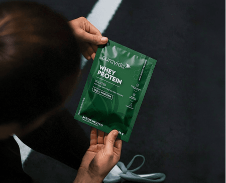 Whey Protein Isolado Puravida sobre bancada de madeira