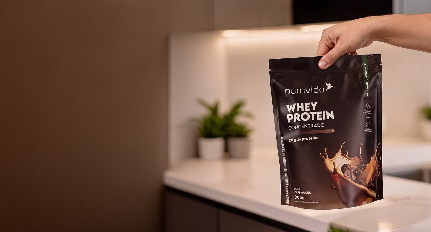 Pouch de Whey Protein Concentrado Café Mocha sobre splash de café com grãos