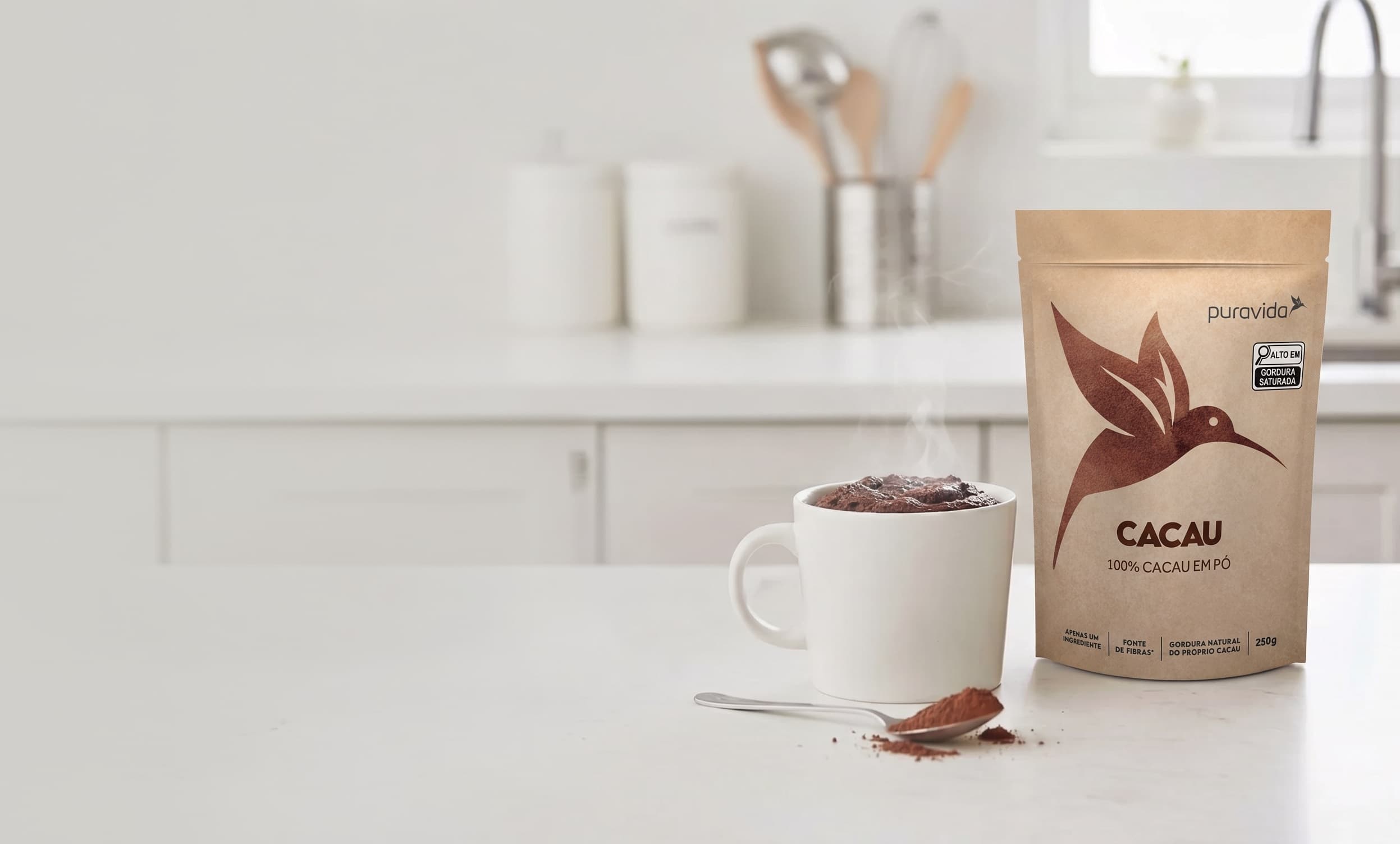 Pouch de Cacau em Pó Puravida em bancada de cozinha com caneca de chocolate quente