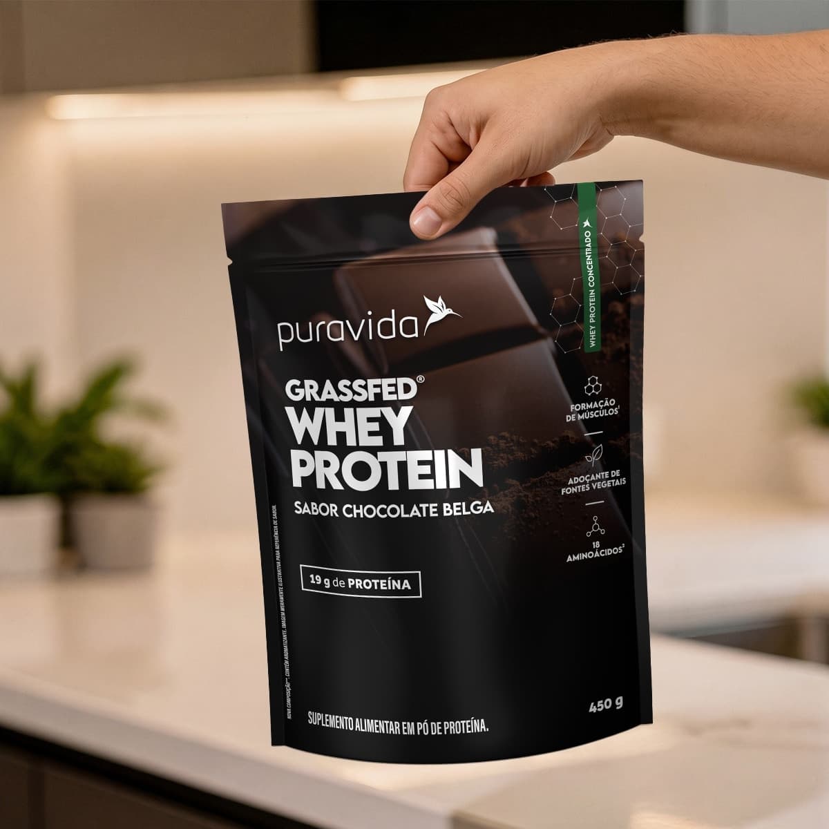 Mão segurando o pouch Whey Grassfed