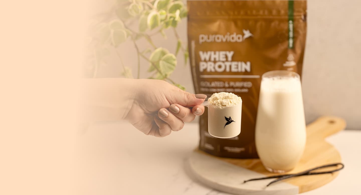 Mão segurando scoop de Whey Protein Isolado Vanilla